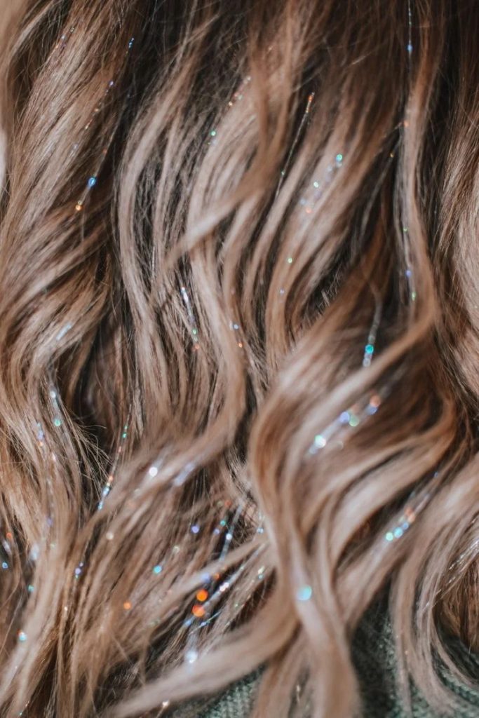 Decorative hair tinsel applied to enhance hairstyle with a touch of sparkle at Inked Beauty Bar.